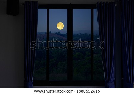 Lonely full moon over the mountains in window view Royalty-Free Stock Photo #1880652616