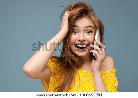 Closeup Photo of attractive crazy amazed surprised young woman wearing casual stylish clothes standing isolated over background with copy space holding and using mobile phone looking at camera