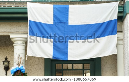 National flag of the Finnish country displayed at the entrance of the house                               