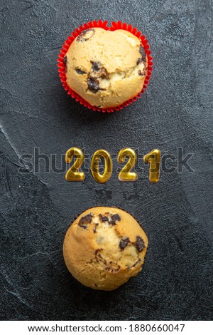 Vertical view of a delicious cupcake and golden text on dark background