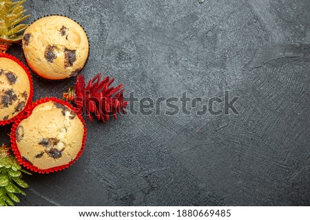 Horizontal view of freshly baked delicious cupcakes and colorful decorations on dark background
