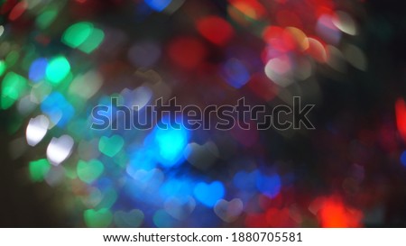 Heart shape bokeh in dark fuzzy lights. Christmas theme blur background. Abstract glow wallpaper