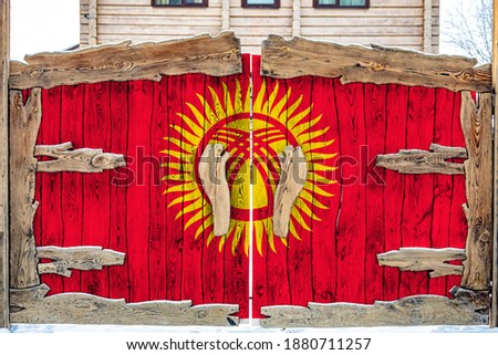 Close-up of the national flag of Kyrgyzstan  on a wooden gate at the entrance to the closed territory. The concept of storage of goods, entry to a closed area. 