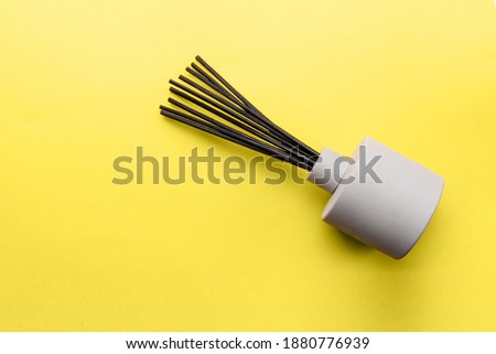 Overhead view to aroma reed diffuser on yellow background, trend and mod colors of 2021 year Ultimate Gray and Illuminating