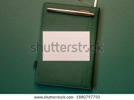 Paper on notebook on green background. Mock up.