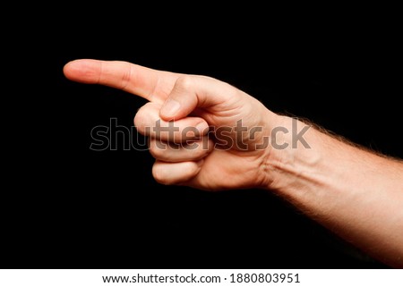 Hand and finger point to something on a black background