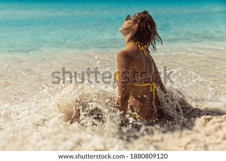 Young lady in yellow bikini on the beach