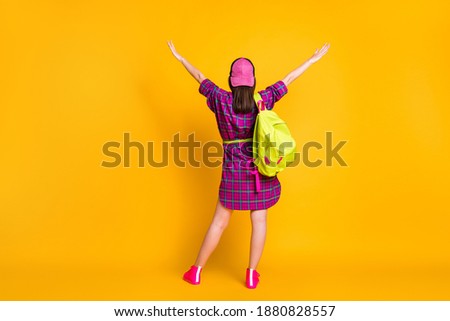 Full length rear back view photo of girl raising hands wear pink dress sneakers bag headwear isolated yellow color background