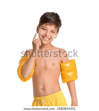 Little boy with sun protection cream on his face against white background