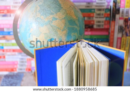 Close-up of open books on the table in the library The globe and the stack of books as the background selective focus and shallow depth of field