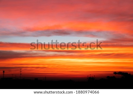The clear blue reddish orange, blue and purple sky at the sunset time with the silhouette shapes of buildings creates the sense of calmness, meditation, beauty of natur.  Royalty-Free Stock Photo #1880974066
