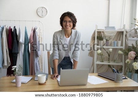 When hobby becomes business. Portrait of successful young woman designer dressmaker florist looking at camera with happy smile. Female owner of workshop studio atelier posing by desk enjoying work Royalty-Free Stock Photo #1880979805