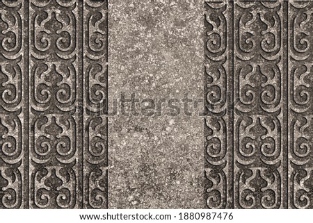 Ornamental print on the granite surface. Vintage ornament on the stone. Embossed drawing. Close-up. Stone texture. Pattern on the stone. Embossed pattern. Wallpaper. Tile. Close-up of seamless texture
