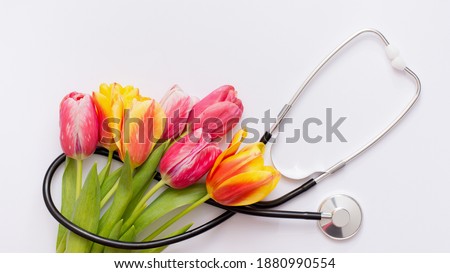 Bunch of pink tulips and stethoscope on white background. National Doctor's day. Happy nurse day. Royalty-Free Stock Photo #1880990554