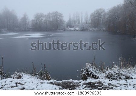 Beautiful winter lake with fog and winter landscape