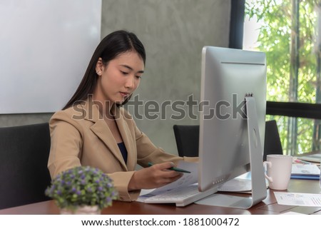 Beautiful office woman  sit at table in office ,she work  ,search information on notebook look friend and smile agreement.
