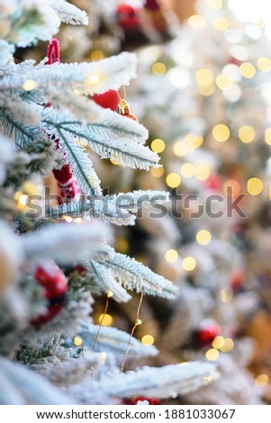 Christmas fairy light on white snow tree. Vertical blurred background.