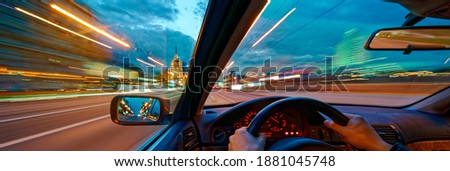 Movement of the car at night at high speed view from the interior with driver hands on wheel. Concept spped of life. Long exposure photo. Royalty-Free Stock Photo #1881045748