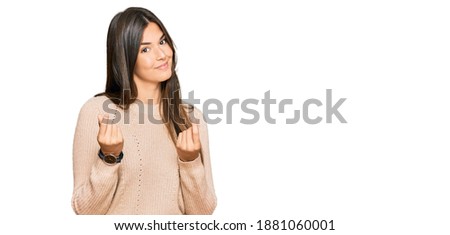 Young brunette woman wearing casual winter sweater doing money gesture with hands, asking for salary payment, millionaire business 