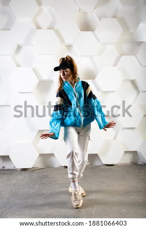 Teenage female dancing hip-hop in a studio, casual clothes