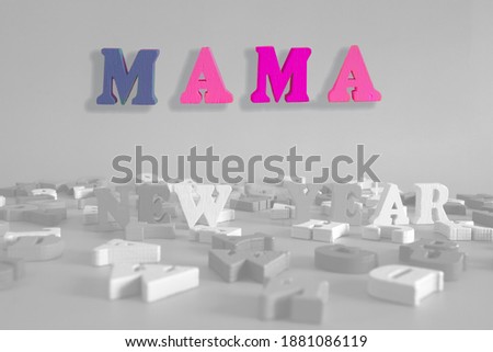 word mama on a black and white background consists of colorful wooden letters in the abc alphabet block, which are the place for the ad text. English learning concept
