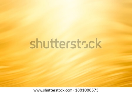 Abstract golden background with bright light on top, which looks like sun light. Blurred gold bg.