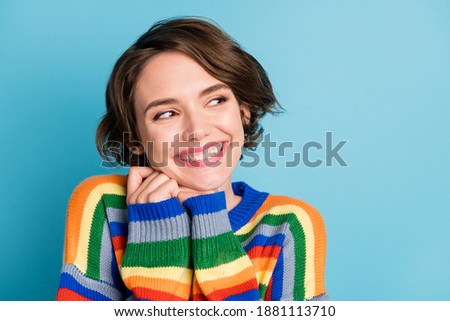 Photo portrait of cute woman looking to side holding head with two hands isolated on pastel blue colored background