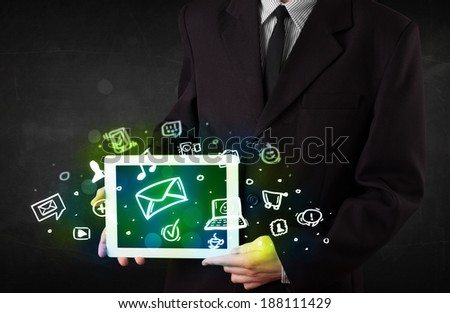 Person holding a white tablet with media icons and symbols