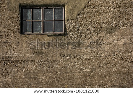 Old and worn brown window set in a rustic old concrete wall with plenty of copy space.