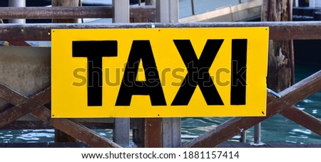 Sign With Taxi cab Icon. Bright yellow taxi parking mark. Large Yellow sign with the inscription TAXI to transport by ship in the navigable canals of Venice in Italy
Defocus. Selective focus