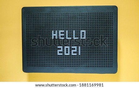 Hello 2021 on letter board. Yellow background. New Year celebration 