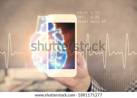 Double exposure of man's hands holding and using a phone and heart drawing. Medical education concept.