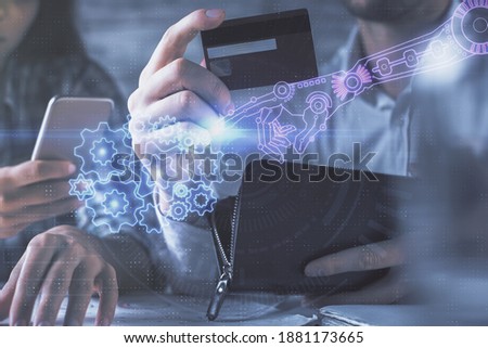 Double exposure of man and woman on-line shopping holding a credit card and data theme hologram drawing. Ai and E-commerce pay on-line concept.