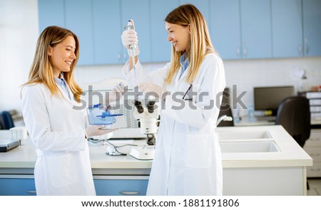 Cute female researchers in white lab coat working in the laboratory