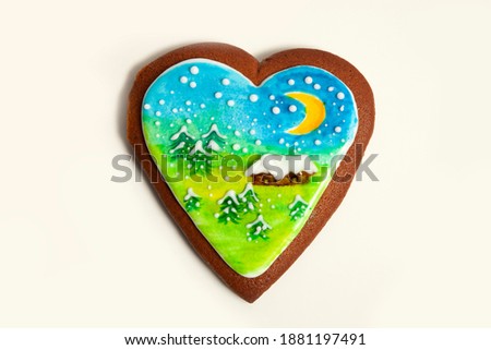 Gingerbread with beautiful hand made drawing of winter scape with food colours. house, moon and spruce trees on it. Isolated on white.