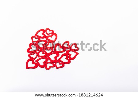 Side view patterned big shape of a heart made of wooden cutting red hearts on the white background. Valentine's day, love concept. Gift, message for lover. Space for text.
