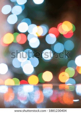 Round colored lights out of focus and their reflection