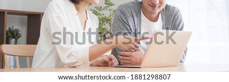 A couple using a computer in the living room Royalty-Free Stock Photo #1881298807