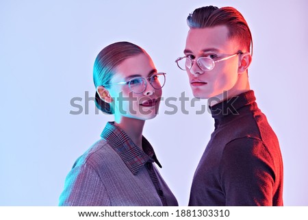 Fashion studio shot. Handsome young man and beautiful young woman posing together in stylish glasses. Optics. Business style. Royalty-Free Stock Photo #1881303310