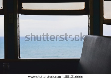 There is a blue sea outside the window of the air-conditioned train.