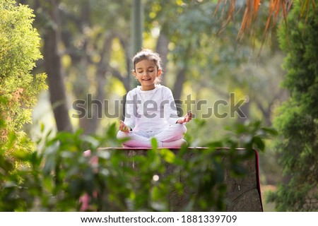 kids doing yoga pose in the park outdoor Royalty-Free Stock Photo #1881339709