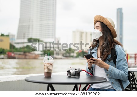 Asian woman wearing face mask when traveling and selfie photo by boat transportation to prevent covid19 virus infection. Tourist female using smartphone search for route location hotel at thailand