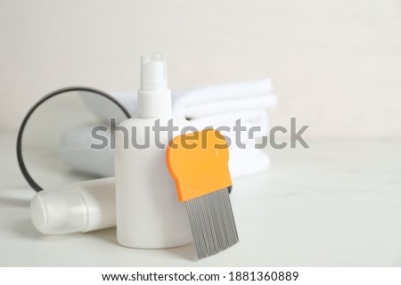 Cosmetic products, lice comb and magnifying glass on white table. Space for text
