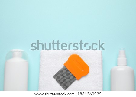 Products for anti lice treatment, metal comb and towel on light blue background, flat lay. Space for text