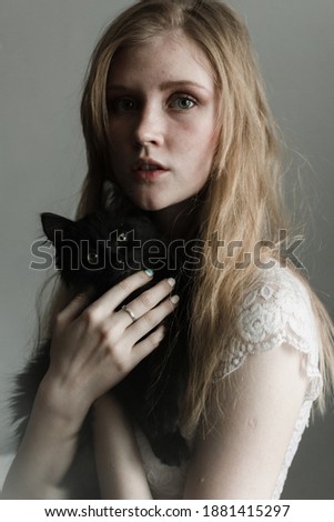 Young blonde hair woman with black cat