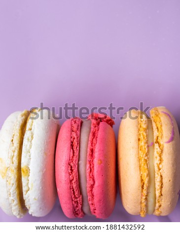 Colorful french cookies macarons set on pink background. Tasty fruit, almond sweet cookies, cake macaron. Holiday backdrop design.