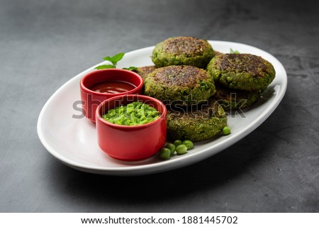 Hara bhara Kabab or Kebab is Indian vegetarian snack recipe served with green mint chutney over moody background. selective focus Royalty-Free Stock Photo #1881445702
