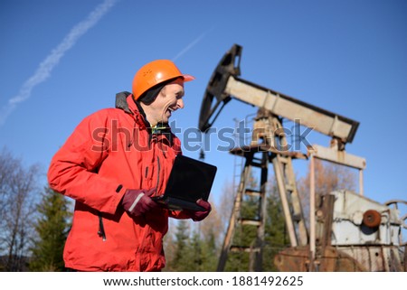 Ancient oil and gas field in the Ukrainian Carpathians, begun under Austria-Hungary, Poland. Gas worker engineer oil worker checks the operation of the pipeline and pump at the beginning of winter.