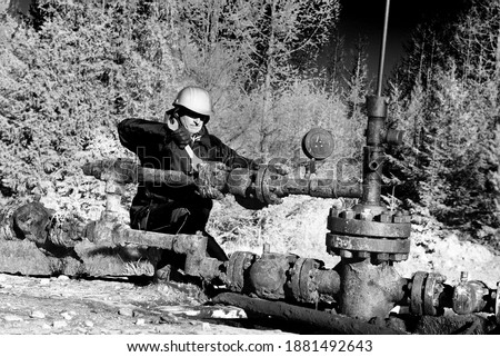 Ancient oil and gas field in the Ukrainian Carpathians, begun under Austria-Hungary, Poland. Gas worker engineer oil worker checks the operation of the pipeline and pump at the beginning of winter.
