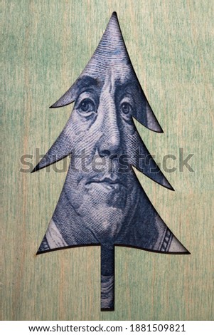 christmas tree with benjamin franklin's face with one hundred dollar bill